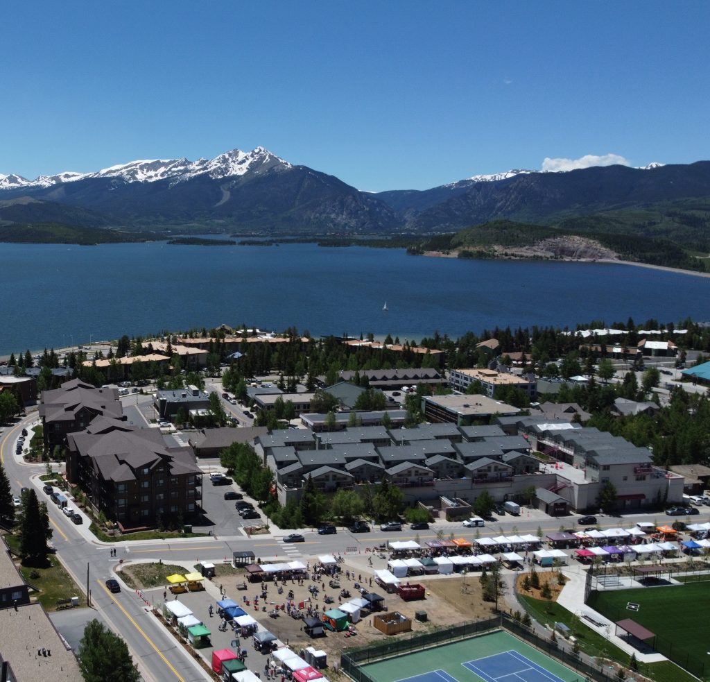 Drone overview of La Riva Condos with park in the forground and the Lake and Mountains behind